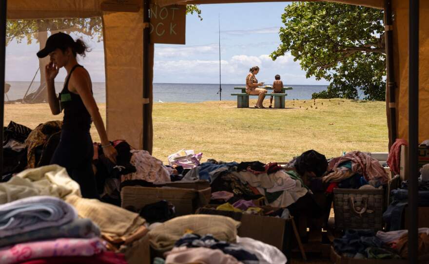 Donated clothes are piled at a distribution center at Honokawai Beach Park this week. The park has become a community gathering spot since the Lahaina fire. It's where Luz Vargas' son took his first steps and where she hopes to hold a memorial on Sunday — what would have been his 15th birthday.