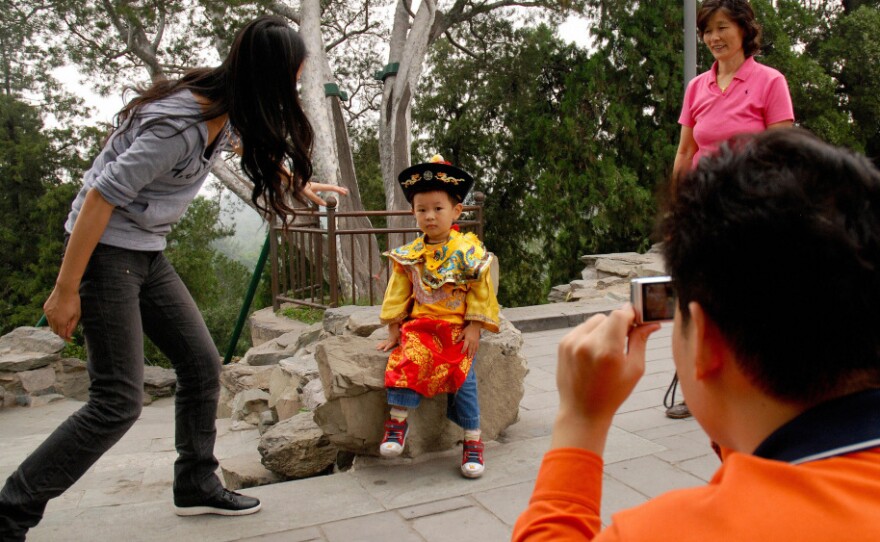 A Chinese family coaxes their son to pose in a "little emperor" costume at a park in Beijing last year. China introduced its one-child policy for urban Chinese in 1976, resulting in a generation of sibling-less offspring.
