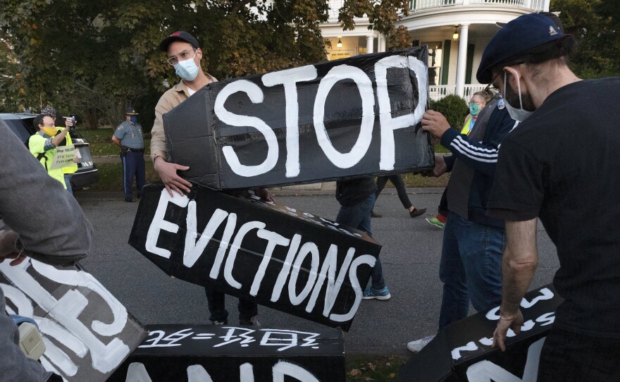 Housing activists erect a sign in front of Massachusetts Gov. Charlie Baker's house in Swampscott, Mass. on Oct. 14, 2020. The Centers for Disease Control and Prevention has extended a moratorium on evictions until the end of July.