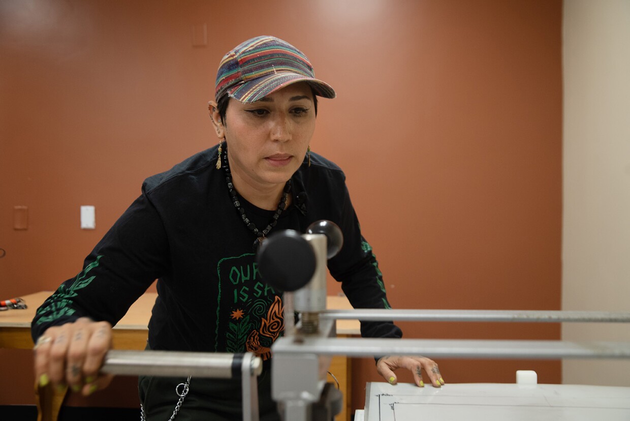 Irie Zepeda of Por La Mano Press is shown demonstrating a pinwheel printing press at the Chicano Park Museum and Cultural Center on Oct. 7, 2025
