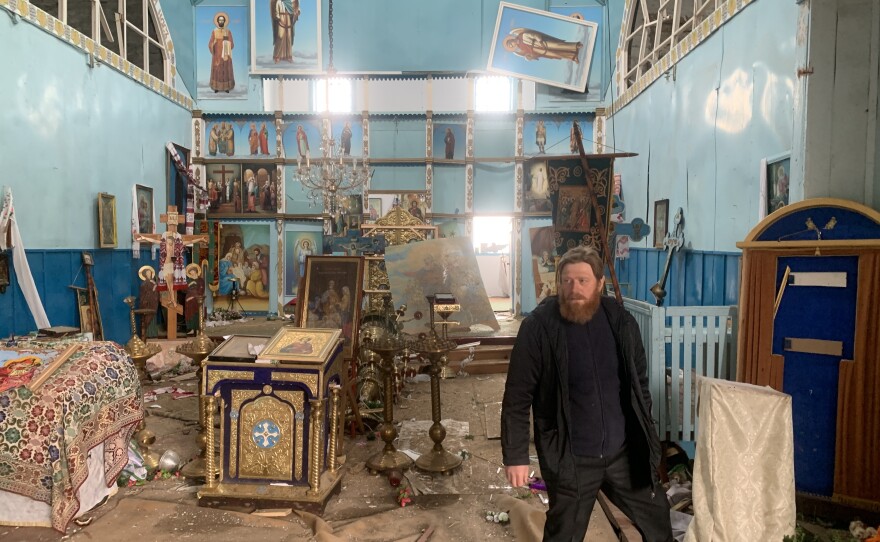 Father Oleksandr Yarmolchyk stands inside the demolished nave of his Orthodox church in Peremoha, Ukraine on April 17. He says the Russians bombed his church and held him against his will.