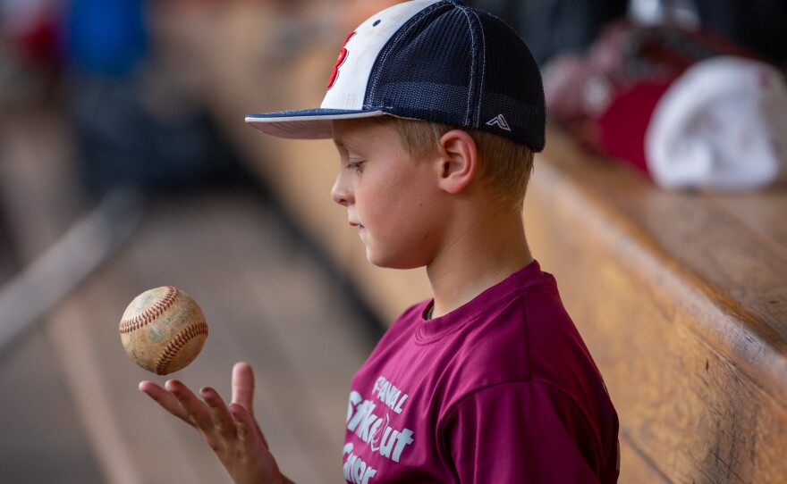 Fans of all ages including this young boy, the son of a player for the amateur team known as the Red Sox, turned out to watch his father's team play.