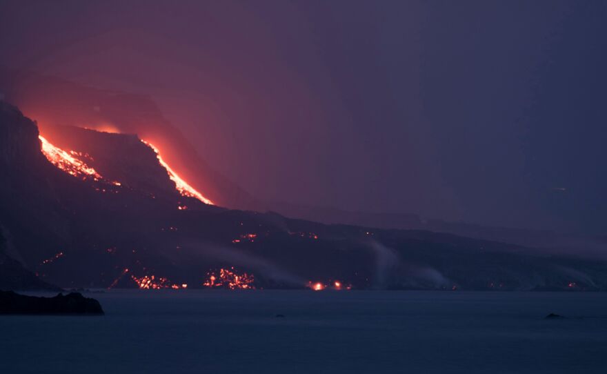 Lava from the Cumbre Vieja volcano falls into the ocean off the Canary Island of La Palma on Saturday. A new flow of highly liquid lava emerged from the volcano on Friday as a huge magma shelf continues to build in the Atlantic ocean.