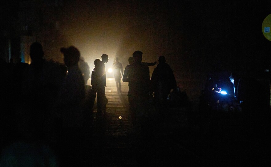 People walk on a street in the dark during a blackout in Havana, Cuba, Saturday, March 21, 2026.