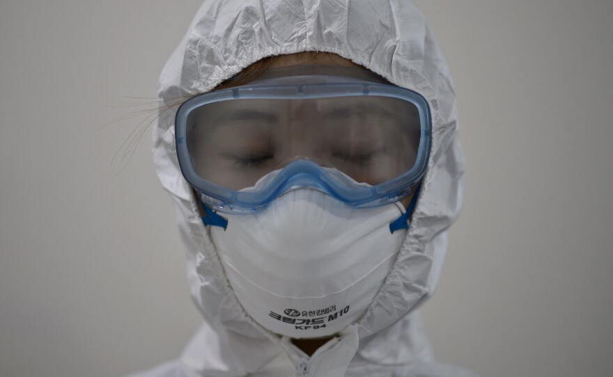 A medical staff member wearing a protective suit waits to enter an isolation ward for patients with Middle East Respiratory Syndrome, MERS, in South Korea.