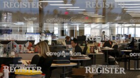 Arts writer Richard Chang, center, works on his computer in the newsroom of the Orange County Register in Santa Ana, Dec. 27, 2012.