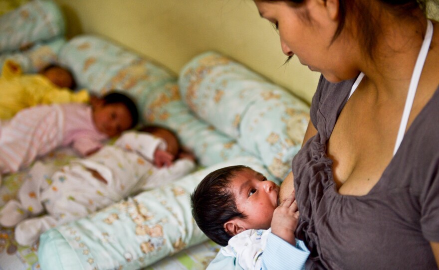 A woman breastfeeds her child as she waits to donate milk to a milk bank in Lima. The donations are used for babies whose mothers can't provide breast milk.
