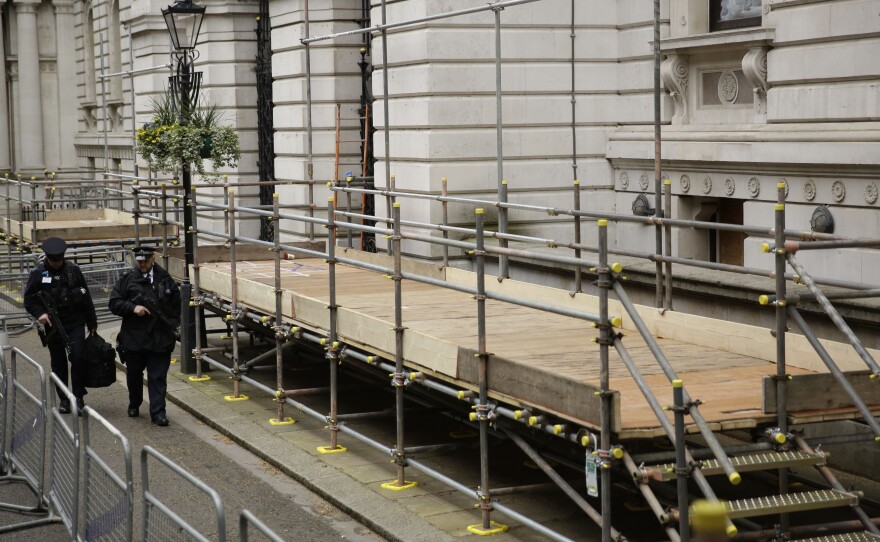 British police officers walk past newly erected media stands for the general election in Downing Street, London, on Tuesday. Britain goes to the polls on Thursday.