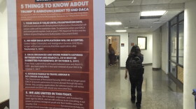 A student walks past a tip sheet for Deferred Action for Childhood Arrivals recipients who fear deportation that is taped to a window on the University of California, Berkeley campus in Berkeley, Calif., Sept. 7, 2017. 