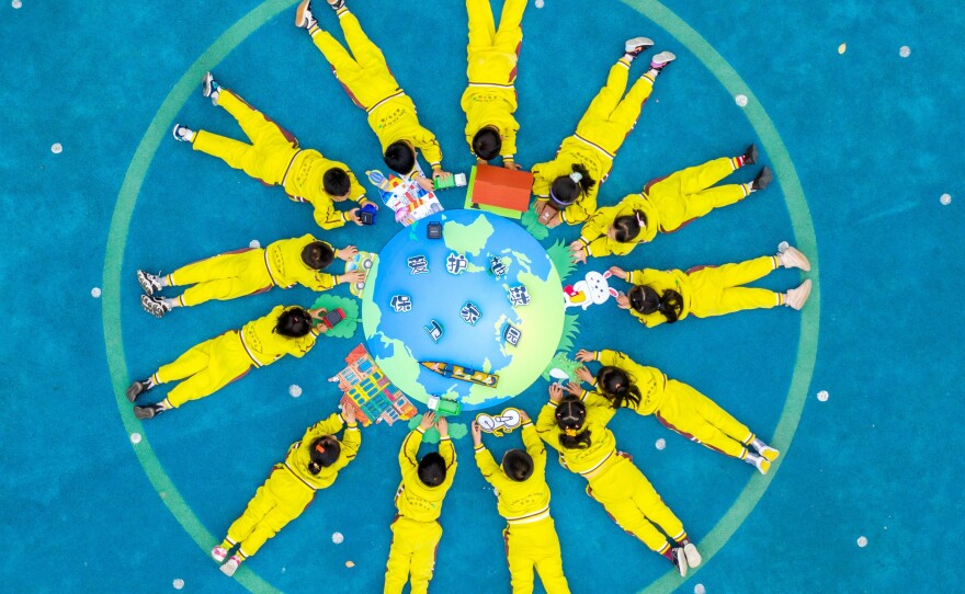 Children make an image of the Earth with green materials at a kindergarten on the 52nd Earth Day on April 22 in Changxing County, Zhejiang Province of China.