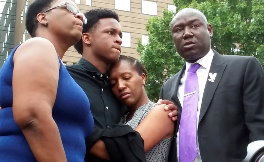 Brandt Jean, center left, brother of shooting victim Botham Jean, hugs his sister Allisa Charles-Findley, during a news conference outside the Frank Crowley Courts Building on Monday, Sept. 10, 2018, in Dallas, about the shooting of Botham Jean by Dallas police officer Amber Guyger on Thursday. He was joined by his mother, Allison Jean, left, and attorney Benjamin Crump, right.