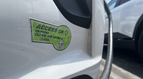 An electric vehicle with a Clean Air Vehicle decal charges at a public lot in Encinitas, Aug. 12, 2025.