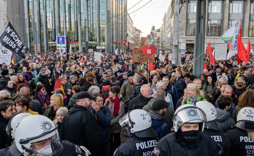 Police stand in front of protesters during a demonstration of Germany's "Querdenker" (Lateral Thinkers) movement in November, in Leipzig, eastern Germany.