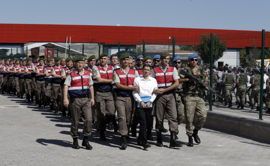 Paramilitary police and members of the special forces escort unidentified suspects of last year's failed coup outside the courthouse at the start of the trial Tuesday in Ankara, Turkey.