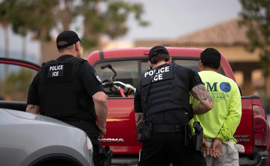A U.S. Immigration and Customs Enforcement (ICE) officer detains a man during an operation in Escondido on July 8, 2019.