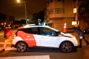 Members of Safe Street Rebel place a cone on a self-driving Cruise car in San Francisco.