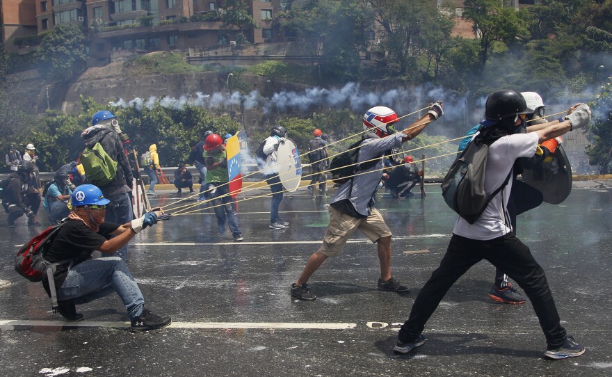 Anti-government protesters aim a giant slingshot with a glass bottle containing fecal matter at security forces in Caracas, Venezuela, on May 10.