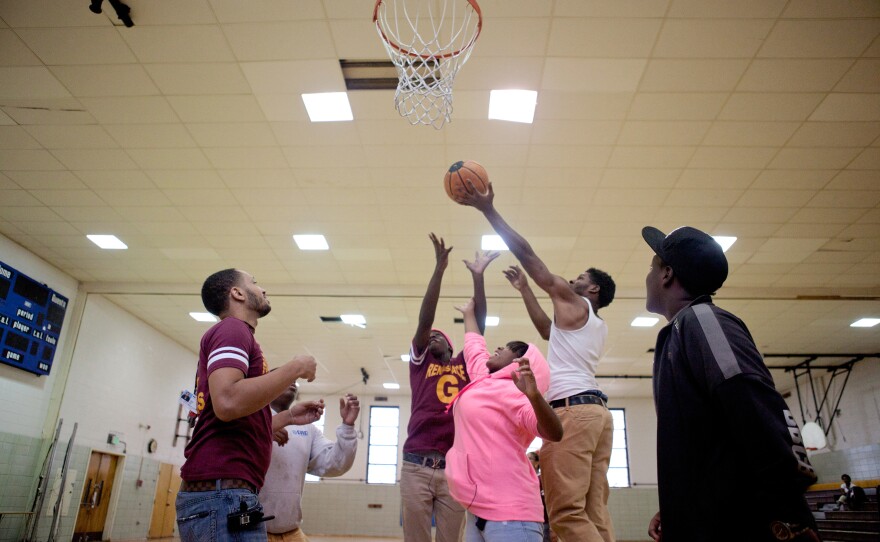 Mentor Marcus Taylor (left) plays basketball with Renaissance Academy High School students during gym class Oct. 8 in Baltimore.