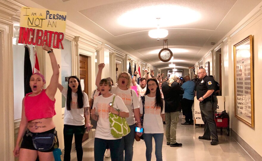 Protesters march through the halls of the Missouri Capitol outside the House chamber on Friday, May 17, 2019, in Jefferson City, Missouri, in opposition to legislation prohibiting abortions at eight weeks of pregnancy. Missouri's Republican-led Legislature has passed a sweeping bill to ban abortions at eight weeks of pregnancy, and Republican Gov. Mike Parson is expected to sign it. The House approved the measure Friday May 17, 2019.