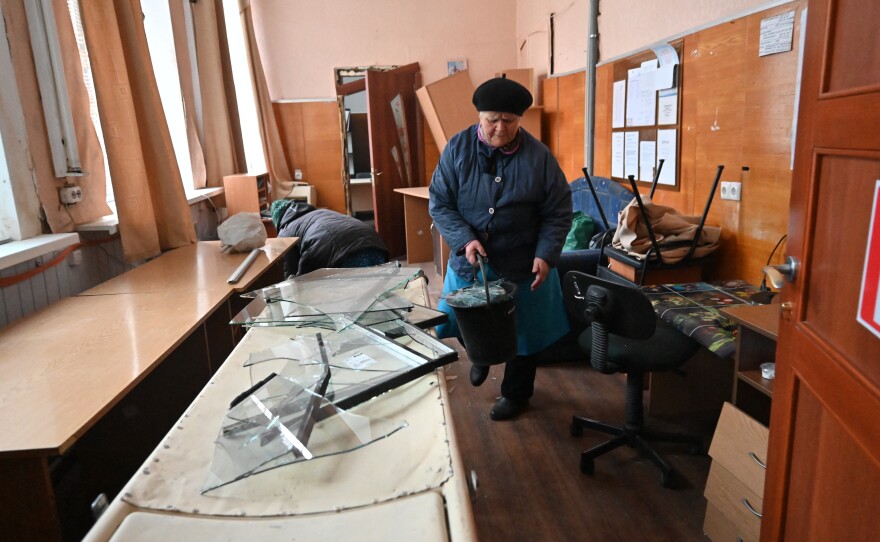 Kharkiv: A local resident removes shards of glass from the windows of an oncology center damaged after a missile strike.