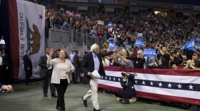 Democratic presidential candidate Sen. Bernie Sanders, I-Vt., center, and wife, Jane, wave toward the crowd as they arrive for a rally in Carson, May 17, 2016.