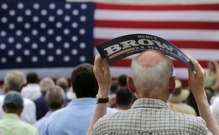 Paul Moccia, of Atkinson, N.H., shades the top of his head from the sun, while waiting for New Hampshire Senate candidate Scott Brown to be endorsed by Mitt Romney at an event in Stratham, N.H., on July 2, 2014.