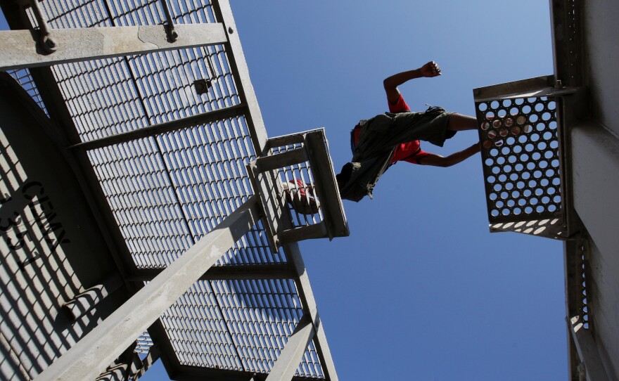 A Central American migrant jumps between cars on a freight in Mexico's Chiapas state in 2013 during the journey north.