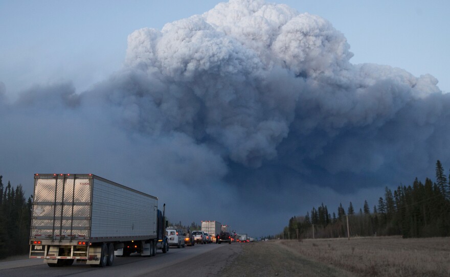 Drivers wait outside Fort McMurray for clearance to take firefighting supplies into town on Thursday.