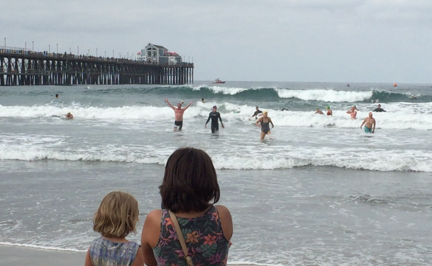 Competitors come ashore after swimming a mile around the Oceanside Pier during the annual Oceanside Labor Day Pier Swim, Sept. 5, 2016.