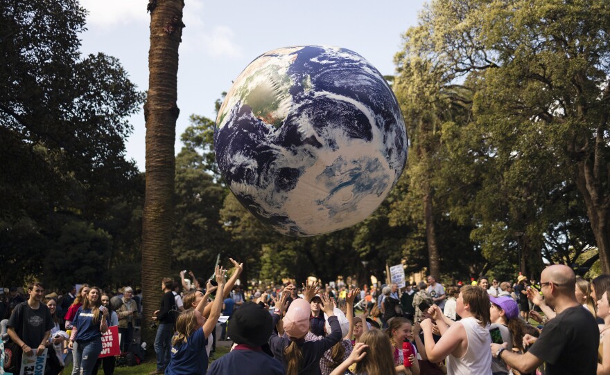 Protesters throw a large globe in Sydney. Rallies held across Australia are part of a global day of action demanding action on the climate crisis.