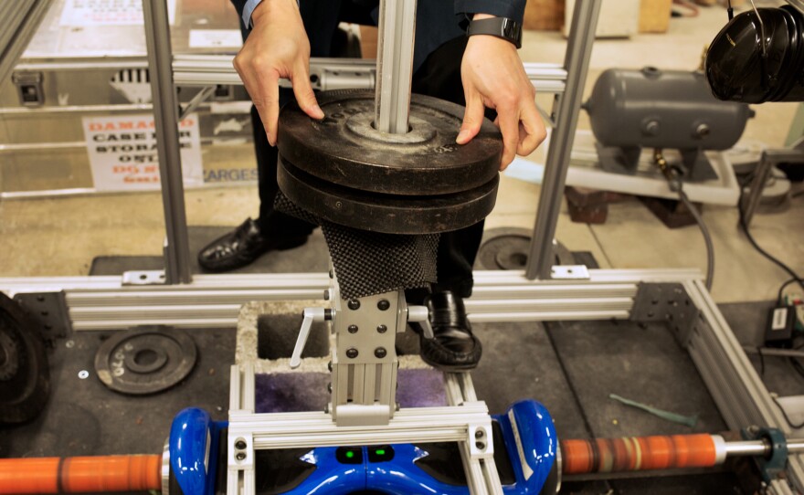 Electrical engineer Doug Lee adds weights to the set-up the lab built to test hoverboards.