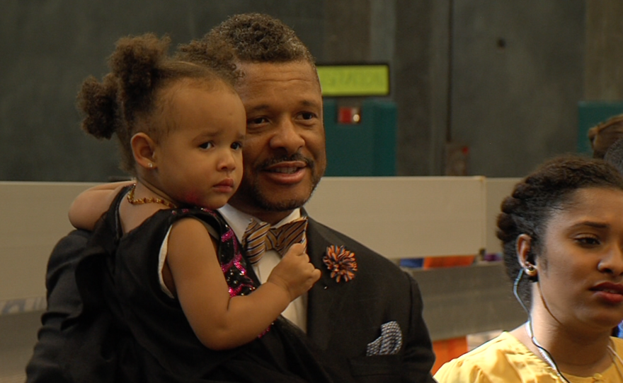 Alliance San Diego Associate Director Chris Wilson holds his daughter during the All Peoples Breakfast, Jan. 18, 2016.