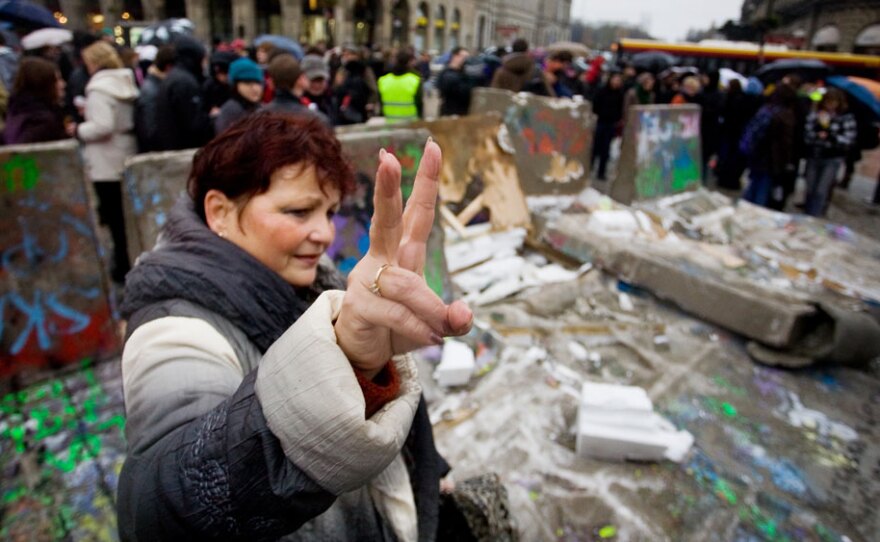 A Polish woman flashes the victory sign near the destroyed remains of a replica of the Berlin Wall in central Warsaw as a part of celebrations marking the 20th anniversary of the fall of the Berlin Wall, on Nov. 9, 2009.