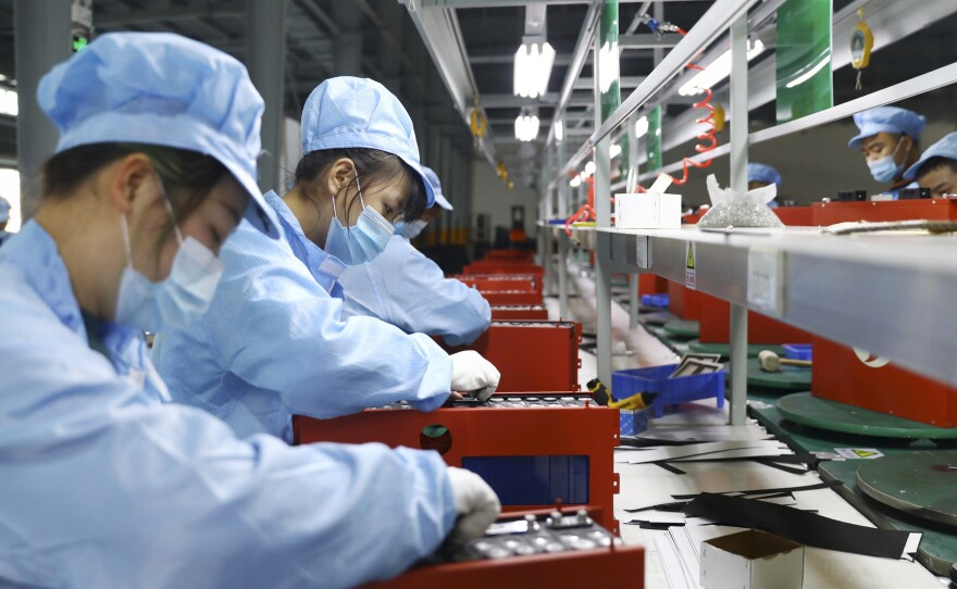Employees work in the workshop of a lithium battery manufacturing company in Huaibei, eastern China, on Nov. 14. China posted a record trade surplus in November, led by a surge in exports to the United States.