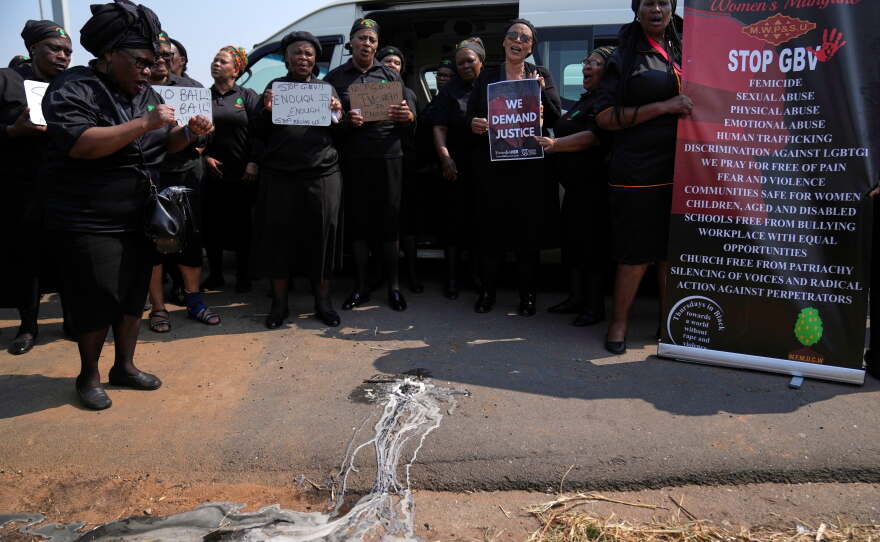 Members of a women's church group sing next to a melted candle as they pay their respects at the site where the body of a woman was discovered the previous week, in Kempton Park, South Africa, east of Johannesburg, Thursday, Sept. 17, 2026.