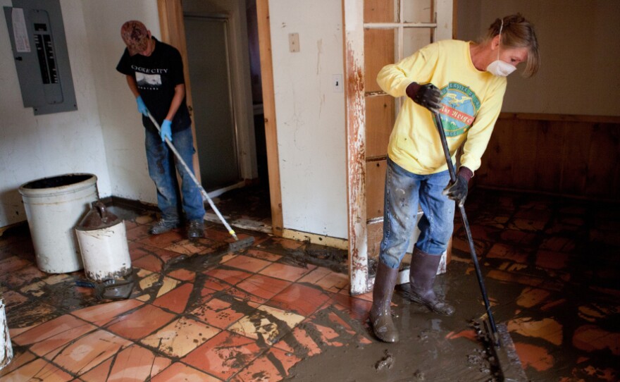 Joyce Roy (right) and Oscar Smith clean up mud from flooding caused by Tropical Storm Irene, in an apartment on West Main Street last month in Wilmington, Vt. The nearby Deerfield River overflowed its banks a few days earlier, inundating homes and businesses in the downtown area.