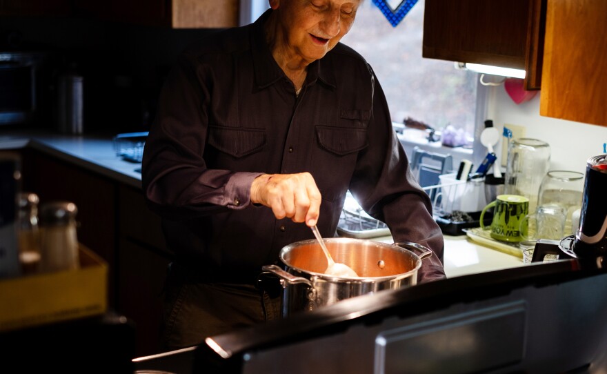Dr. Carl Shy, a public health researcher, cooks on his electric stove at his home. In 1970, he published a study showing that families exposed to greater levels of the air pollutant nitrogen dioxide outdoors had higher rates of respiratory illness than families in less-polluted areas.