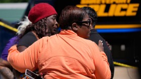 People console each other as they gather at the scene of a mass shooting in Shreveport, La., on Sunday.