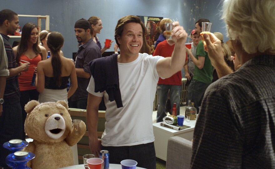 Ted (voiced by Seth MacFarlane) and John (Mark Wahlberg) drink shots with Sam J. Jones in "Ted."