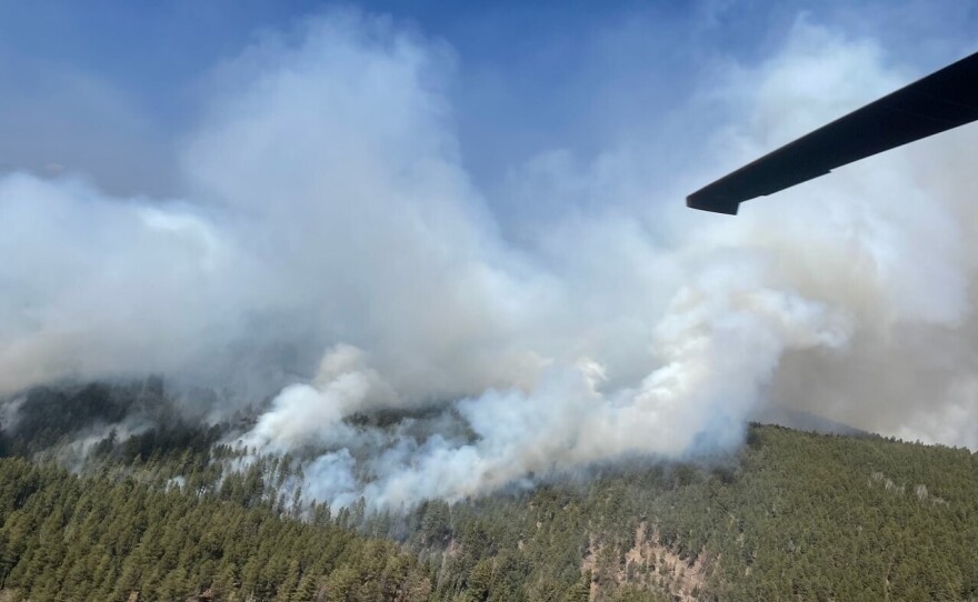 A New Mexico National Guard Aviation UH-60 Black Hawk flies as part of firefighting efforts, dropping thousands of gallons of water from the air on the Calf Canyon/Hermits Peak fire in northern New Mexico on Sunday.