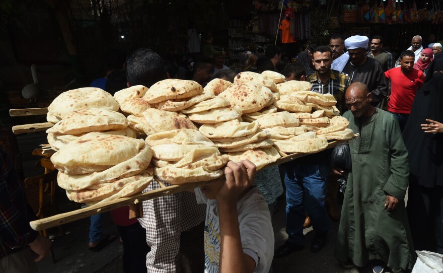 A bread seller walks in the open air market in central Cairo in 2018.