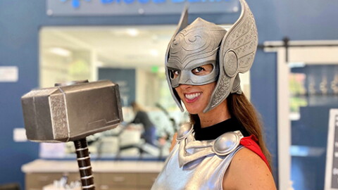 A woman dressed as Lady Thor poses before the San Diego Blood Bank logo in this undated photo.