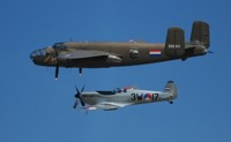 A Dutch B-25 Mitchell (top) and a Spitfire fly over Arromanches-les-Bains, Normandy, on the anniversary of the World War II Allied landings.