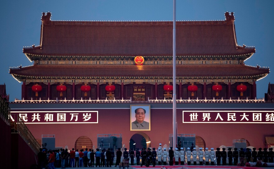 Chinese honor guards stand in formation during the lowering of the national flag in front of Tiananmen Gate in Beijing on Monday, one day before the 70th anniversary of the founding of the People's Republic of China.