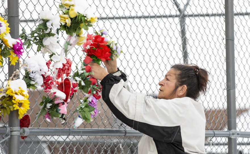 Fleury hangs flowers on the fence outside the detention center where her son died. No one checked on Pepion for hours, despite a policy requiring correctional officers to do inmate checks every 30 minutes.