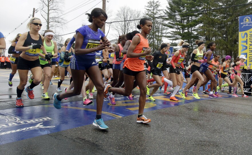 Runners cross the start line in the women's division of Boston Marathon on Monday in Hopkinton, Mass.