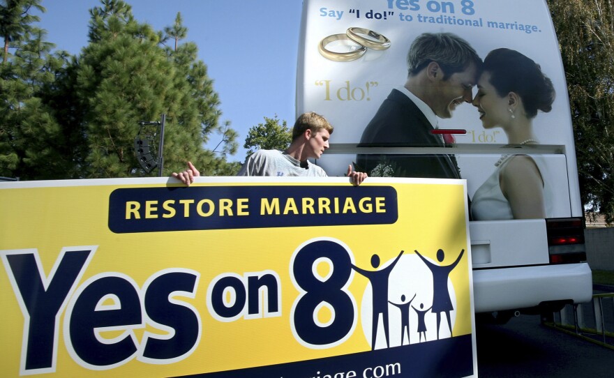 Richie Beanan of Los Angeles puts a sign on a bus in support of California's Proposition 8 gay marriage ban after a rally in Sacramento in October 2008.