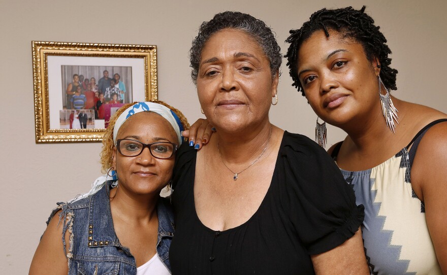 Marie Brisbane, center, and her daughters mourn the death of her husband and their father, Dr. Samuel Brisbane. He was the first Liberian doctor to die in the country's Ebola outbreak.