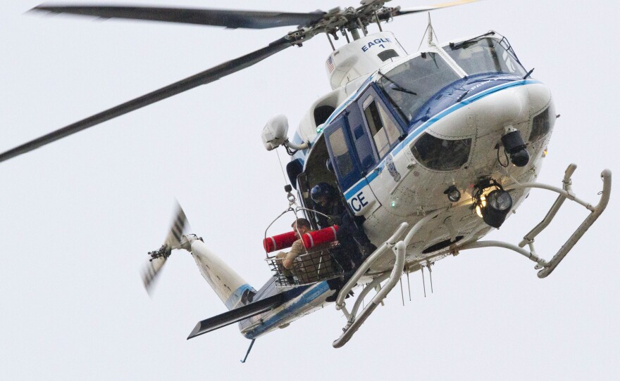 A U.S. Park Police helicopter removes a man in a basket from the Navy Yard.