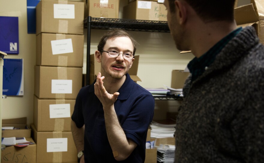 Jonathan Keleher talks with a colleague, Rafael Wainhaus, at work. Keleher was born without a cerebellum, but his brain has developed work-arounds for solving problems of balance and abstract thought.